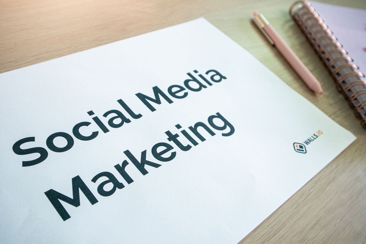 Vue rapprochée d'un document de social media marketing posé sur un bureau avec un stylo et un carnet.